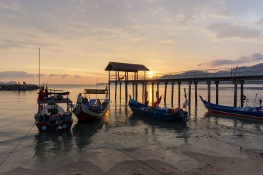 Gün batımında iskelede balıkçı teknesi.