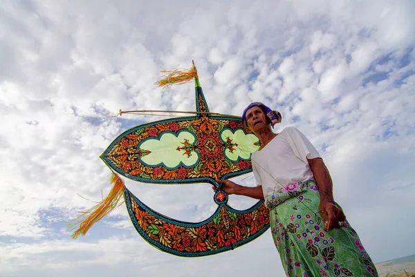 Parlak güneşli bir günde eli uçurtmalı bir adam