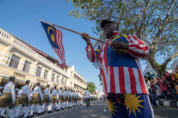 En indian bär malaysisk kostym och viftar med Malaysias flagga. — Stockfoto