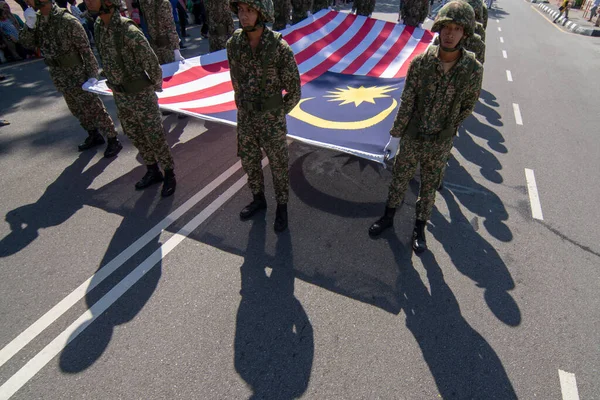 Soldado carrega grande bandeira da Malásia no desfile . — Fotografia de Stock