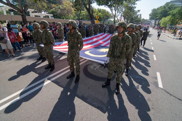 Ulusal Gün geçidinde Malezya bayrağıyla yürüyen asker. — Stok fotoğraf