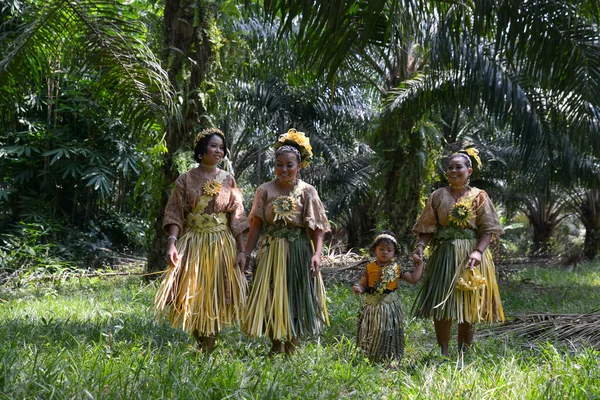 Malaysia's indigenous Mah Meri walk in oil palm plantation. — Stock Photo, Image