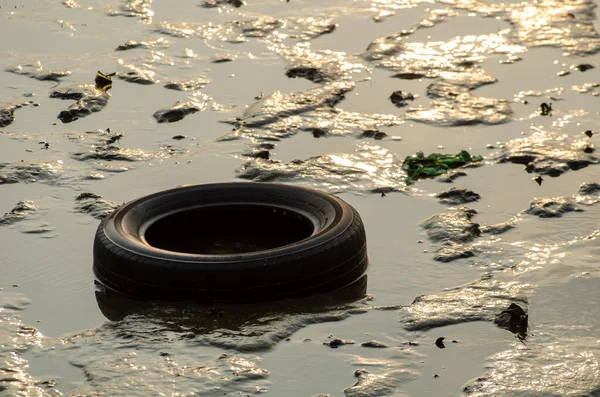 Neumático de coche y otra basura en el mar en la mañana de la luz del sol . —  Fotos de Stock