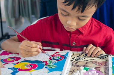 Georgetown, Penang / Malezya - 15 Şubat 2020: Bir çocuk batik çizimi boyadı.