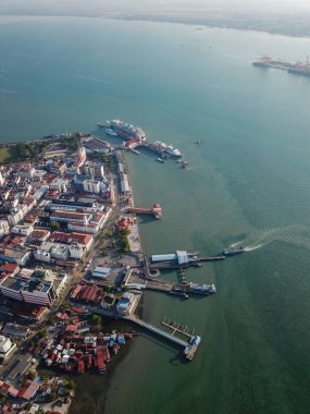 Penang Jetty feribotu geliyor. Arka planda Penang 'ı ziyaret eden yolcu gemisi var..