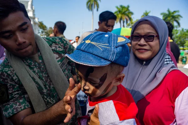 Unbekanntes Kind bekommt Tarnschminke von malaysischem Soldaten — Stockfoto