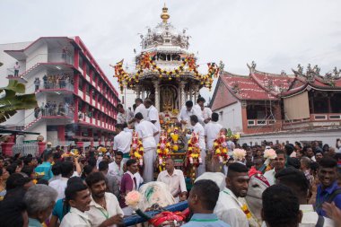 Silver chariot with the devotees with background chinese temple