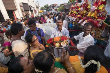 Devotees approach the chariot with bowls of fruit and even hold babies up
