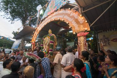 Devotees work together carry statue lord Muruga