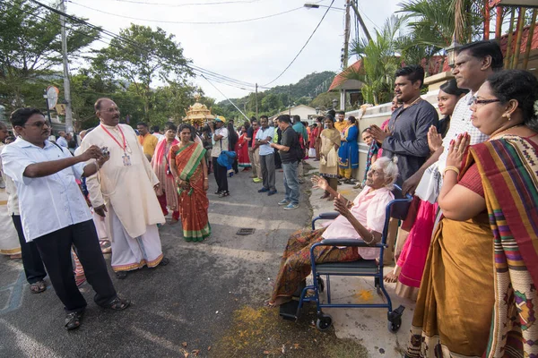 Family take photos during gold chariot procession at housing area. — Stockfoto