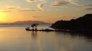 Siluet balıkçı teknesi gün doğumunda denize açılacak..