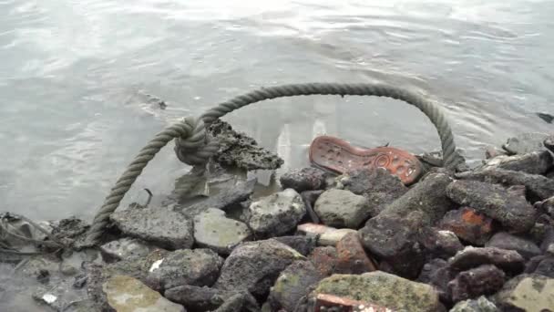 汚れた海岸でのロープや靴のゴミ — ストック動画