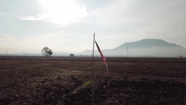 Broken Malaysia flag hang at the dry clay open area. — Stock Video