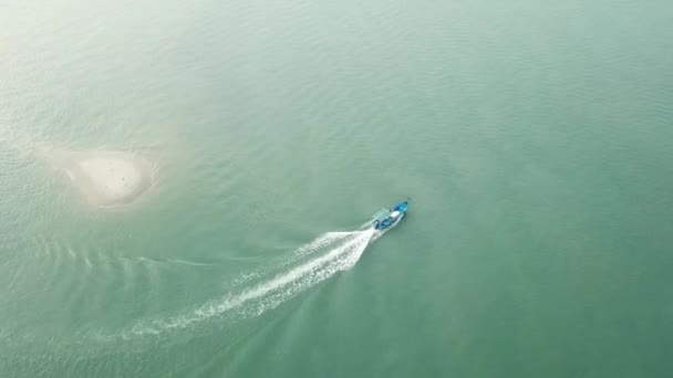 Vista aérea barco de pesca passar uma pequena ilha aparecem durante a maré baixa na Malásia . — Vídeo de Stock