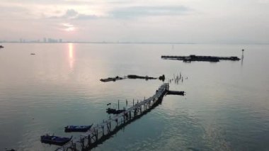 Arka planda Penang Köprüsü olan balıkçı iskelesi..