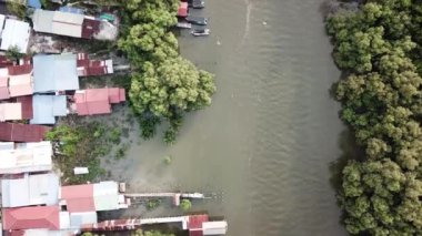 Nehir kıyısındaki Malay köyünün üzerinden uç.
