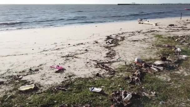 Zanieczyszczenie śmieci wyrzucanych przez człowieka na plażę po pikniku. — Wideo stockowe