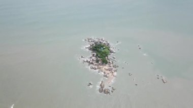 Gökyüzü manzaralı Pulau Tikus, bir sürü büyük kayayla..