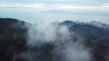 Sis bulutu üzerinde gün doğumu ve Tanjung Tokong, Penang.