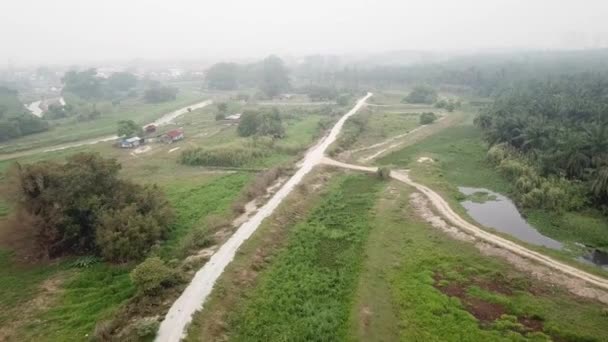 Luftaufnahme grünes ländliches malaiisches Kampung-Dorf auf der grünen Wiese bei nebligem Tag — Stockvideo