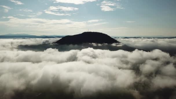 공중에서 보는 구름 이 통신 탑을 이용하여 산꼭대기를 도는 모습 — 비디오