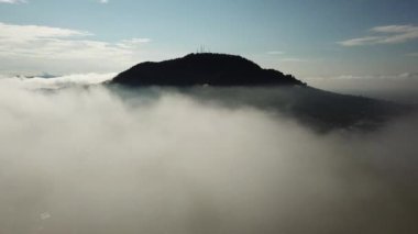 Hava, beyaz bulutların üzerinden uçarak Bukit Mertajam 'daki küçük kasabayı gösteriyor.