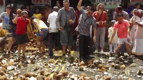 Ludzie rozbijający kokosa na podłodze podczas Thaipusam. — Wideo stockowe