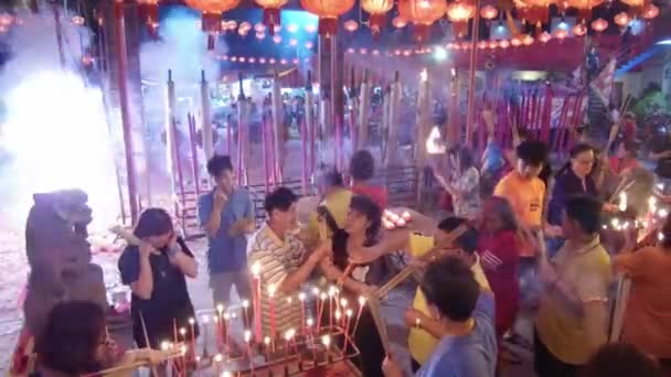 Des craquelins allumés pendant les dévots chinois prient au temple Thai Pak Koong — Video