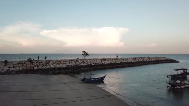 Vuelo aéreo sobre roca cerca de la costa. La gente camina y pesca en roca . — Vídeos de Stock