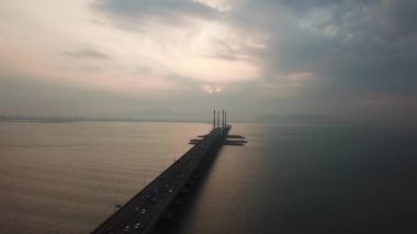 Bulutlu bir sabahta Penang Köprüsü 'nde hava manzaralı araç trafiği.