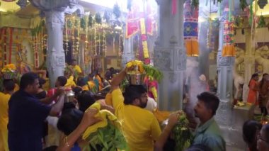 Hintli fanatikler bir demlik süt taşıyorlar.