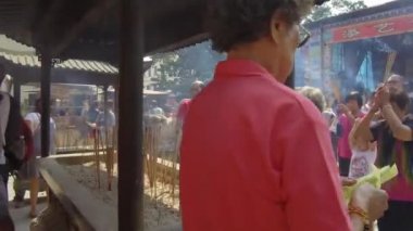 Çinli kadınlar joss çubuğu yakar sabahın erken saatlerinde Merhamet Tanrıçası tapınağında dua ederler..