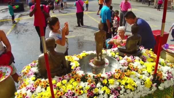 Μια γυναίκα σε αναπηρικό καροτσάκι ρίχνει νερό πάνω από το άγαλμα του Βούδα — Αρχείο Βίντεο