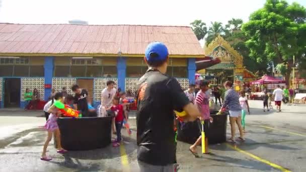 Kinder und Touristen feiern Songkran mit Wasserpistole. — Stockvideo