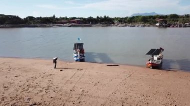 Hava manzaralı bir balıkçı donmuş balıklar için buz torbası taşır..