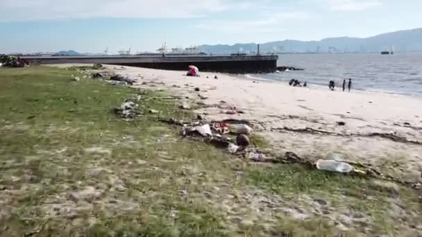 Вид с воздуха мусор бросают в море. Семья веселится на пляже . — стоковое видео
