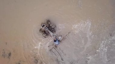 Manzara, çeltik tarlasında traktörle çiftçiyi takip ediyor.