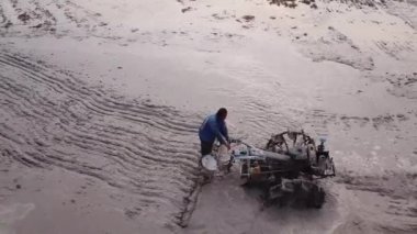 Çiftçi pirinç tarlasında iki teker traktörü kullanıyor..