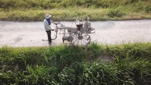 Agricultor mover o trator de duas rodas em pequeno caminho em direção ao campo de arroz . — Vídeo de Stock