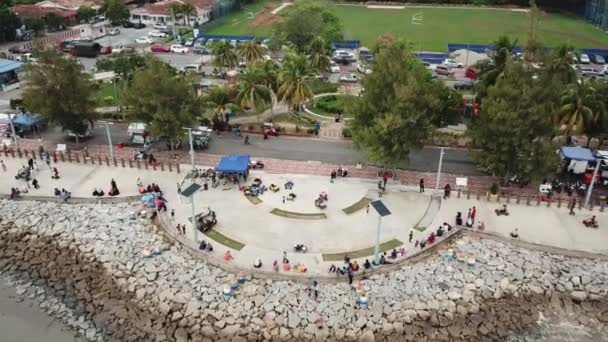Miejscowi Malajczycy spędzają wolny czas na esplanade Pantai Murni Waterfront. — Wideo stockowe