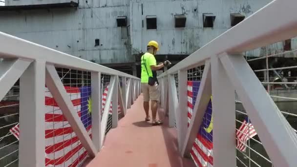 Casco de seguridad de desgaste turístico tomar fotos de los alrededores de Tanjung Tualang — Vídeos de Stock