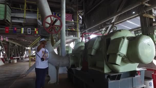 Toeristische gids luidt de bel bij Tanjung Tualang Tin Dredge. — Stockvideo