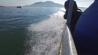 Denizde hareket eden tekne Pulau Aman dalgaları kıran su sıçrattı..