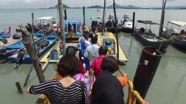 풀 라우 아만 섬을 떠나기 위해 나무로 된 다리에 줄을 서 있는 사람들. — 비디오