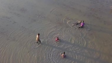 Hava manzaralı Malays kampung çocukları çamur ve su oynayarak eğleniyor.