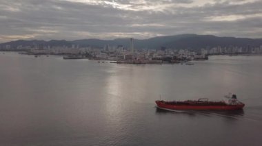 Gökyüzü manzaralı gemi arka planda Penang Adası ile denize yakın hareket ediyor..