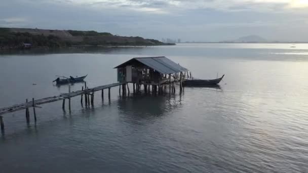 Fisherman on boat beside jetty in morning. — Stock Video