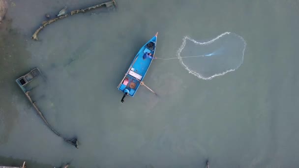 Aeronáutico olhando para baixo pescador jogar casting net ao lado do barco abandonado . — Vídeo de Stock