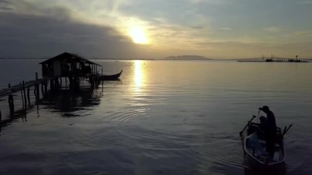 Aerial fisherman row the fishing boat and cast net. Background is Penang Bridge. — Stock Video