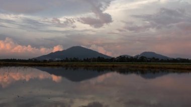 Altından bulutlar, tepeler ve gökyüzü ile günbatımının yansıması